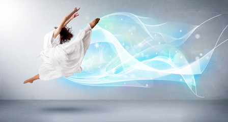 Cute teenager jumping with abstract blue scarf around her