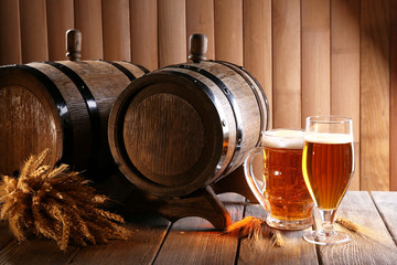 Beer barrel with beer glasses on table on wooden background