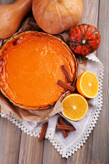 Homemade pumpkin pie on napkin, on wooden background