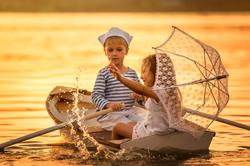 Boy with a girl floating on a boat rowed across the lake