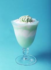 Mint milk dessert in glass bowl on color background