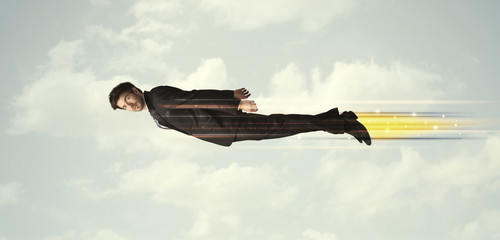 Happy business man flying fast on the sky between clouds