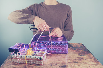 Man at table wrapping presents