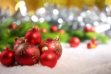Christmas balls on snow on bright background