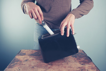 Young man sticking knife in toaster