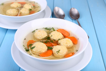 Soup with meatballs and noodles in bowls