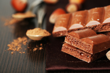 Tasty porous chocolate with nuts on table, close up