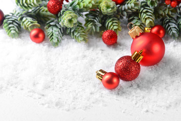 Christmas composition with baubles and fir-tree on snow