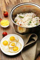 Tasty rice in pan on wooden table