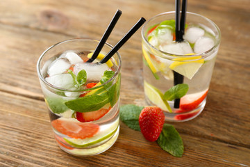 Summer cocktail with ice cubes on wooden table