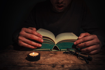 Man reading by candle light