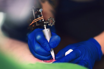 tattooer showing process of making a tattoo