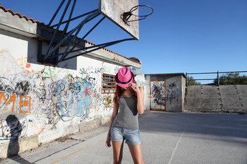 teenager with hat in the playground with  graffiti