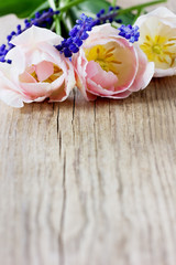 Pink tulips and blue hyacinths on a rustic wooden table