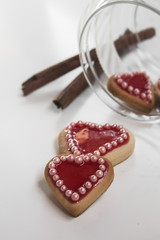 Red hearts cookies on white background and a bowl