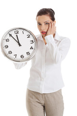 Late woman holding big clock
