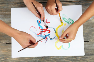 Two girls painting with paintbrush and colorful paints