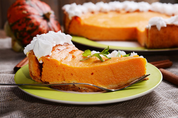 Piece of homemade pumpkin pie on plate on sackcloth background