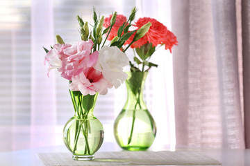 Beautiful flowers in vase with light from window