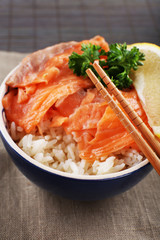 Bowl of boiled rice and fresh salted salmon