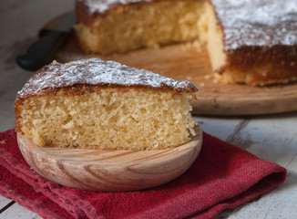 Portion of a sponge cake on a wooden plate