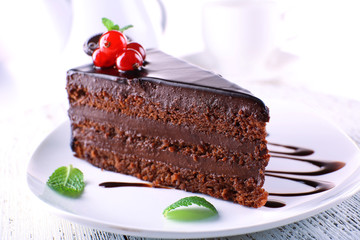 Delicious chocolate cake on plate on table on light background