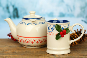 Christmas composition with cup and teapot of hot drink,