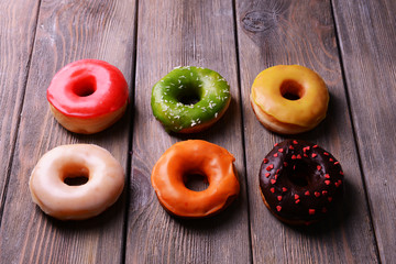 Delicious donuts with glaze on wooden background