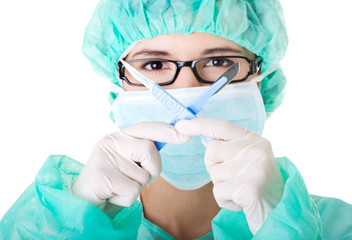 Portrait of female doctor in mask with scalpels
