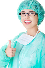 Female doctor in protective mask gesture thumb up