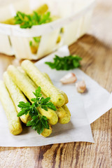 Bread sticks with parsley and garlic on a wooden table