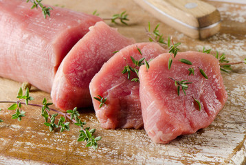 Raw Beef with thyme on a cutting board.