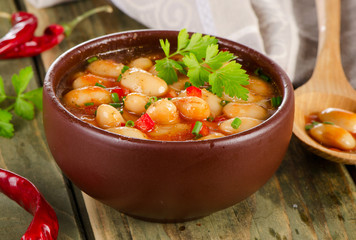 Baked beans in a  bowl on  wooden background .