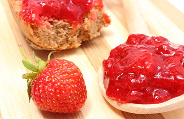 Fresh fruits and strawberry jam on wooden cutting board