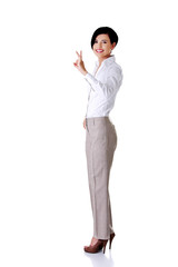 Full length businesswoman showing OK sign