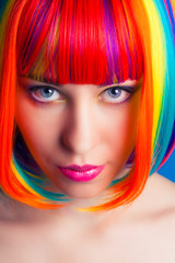 Fototapeta premium beautiful woman wearing colorful wig against blue background