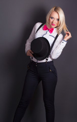 beautiful young woman wearing tophat, bow-tie and braces against