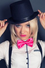 beautiful young woman wearing tophat, bow-tie and braces against