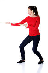 Full length strong woman puling rope
