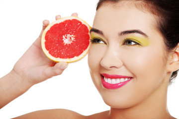 Young nude woman holding grapefruit