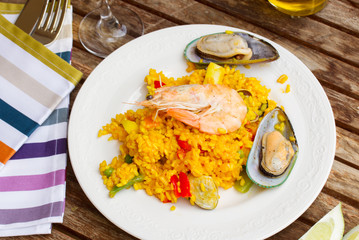 Paella served in plate on wooden table