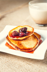 pancakes with jam and coffee on burlap background
