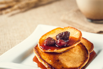 pancakes with jam and coffee on burlap background