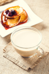 pancakes with jam and coffee on burlap background
