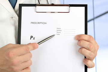 Doctor  showing by pen something on an empty form of   RX prescr