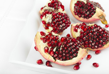Red pomegranate on a white tray