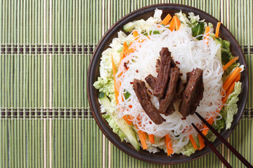 Delicious Asian salad rice noodles and meat top view