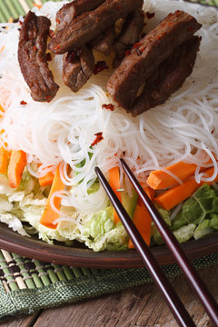rice noodles with slices of meat and vegetables vertical