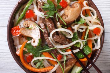 Asian rice noodles with meat, vegetables and shiitake macro