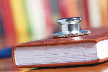 Stethoscope on book with leather cover.